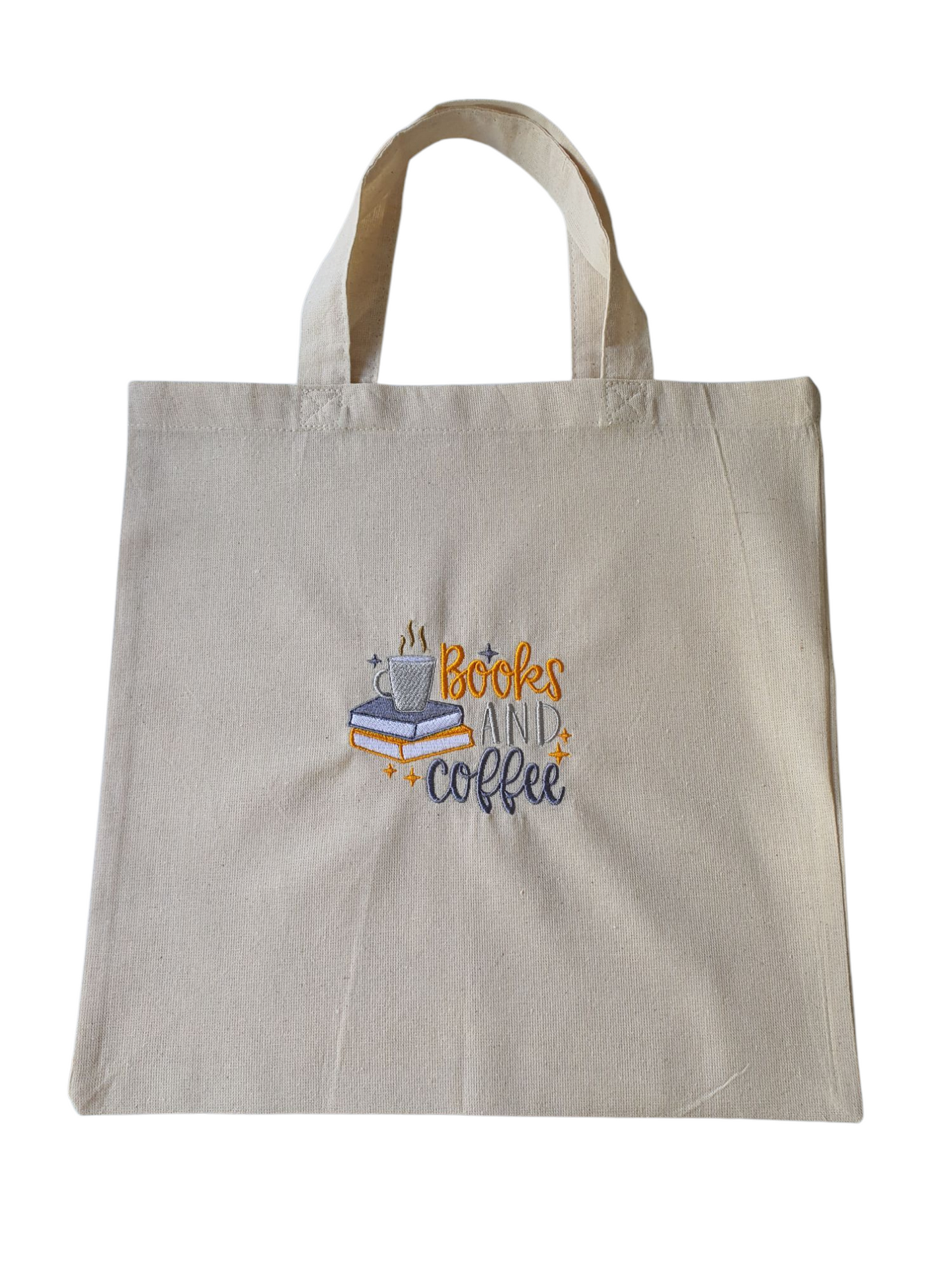 Machine embroidered Tote Bag with a pattern of books and the phrase Books and Coffee. The Tote Bag is approximately 30cms by 30cms (12 inches by 12 inches).