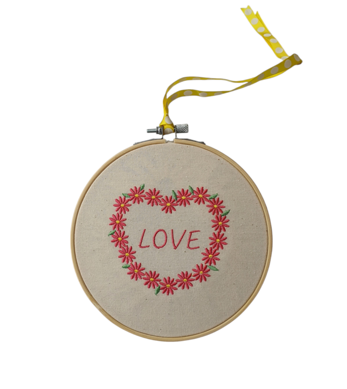 Machine embroidered 6" hoop with a floral heart with the word 'LOVE' in the centre. The hoop is finished off with ribbon, which picks up the yellow centre of the flower, to use for hanging. Would be a lovely wall hanging to show someone you care.