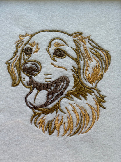 The Golden Retriever machine embroidered dog pattern has been done on white felt and the stabiliser has been retained on the back of the embroidery to add structure.
