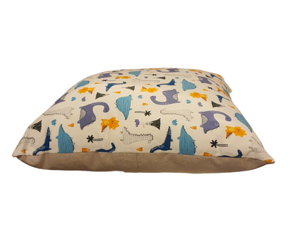 A photo of the side view of the cushion cover which includes the dinosaur pattern to the front and the reverse of the cushion cover showing the neutral fabric and the placement of the enclosed zip.