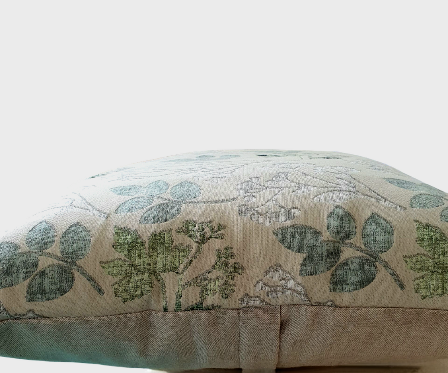 A side on photo of the cushion cover which shows the neutral fabric on the reverse of the cushion cover and the enclosed zip approximately half way down the back of the cushion cover.