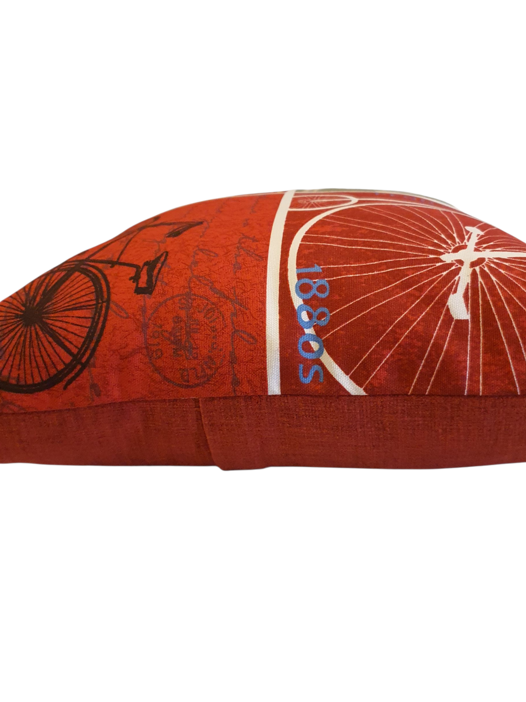 A side view of the cushion showing the patterned front and the complementing red fabric on the reverse of the cushion.