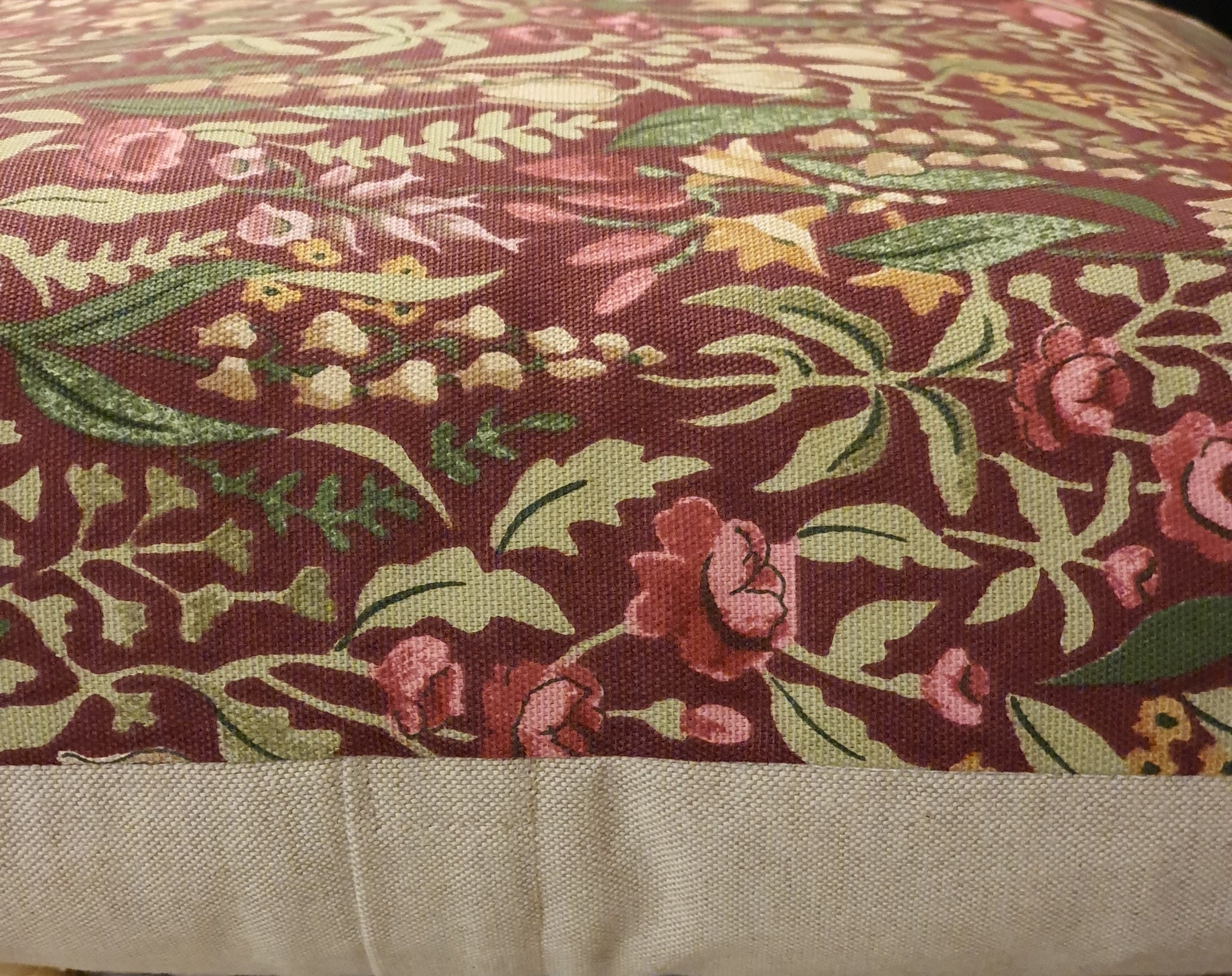 Sideways view showing the patterned fabric to the front and the neutral fabric on the reverse and the enclosed zip.