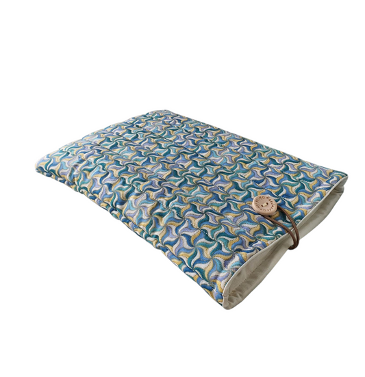 The handmade padded Book Pouch has been made with blue, yellow and white coloured fabric and colours look like a pinwheel pattern.  The Book Pouch is lined with neutral fabric and has elastic and button fastening.