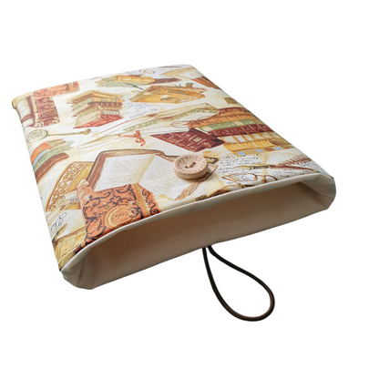 The handmade Book Cover fastens with elastic and a button and the neutral fabric lining can be seen in this photo.