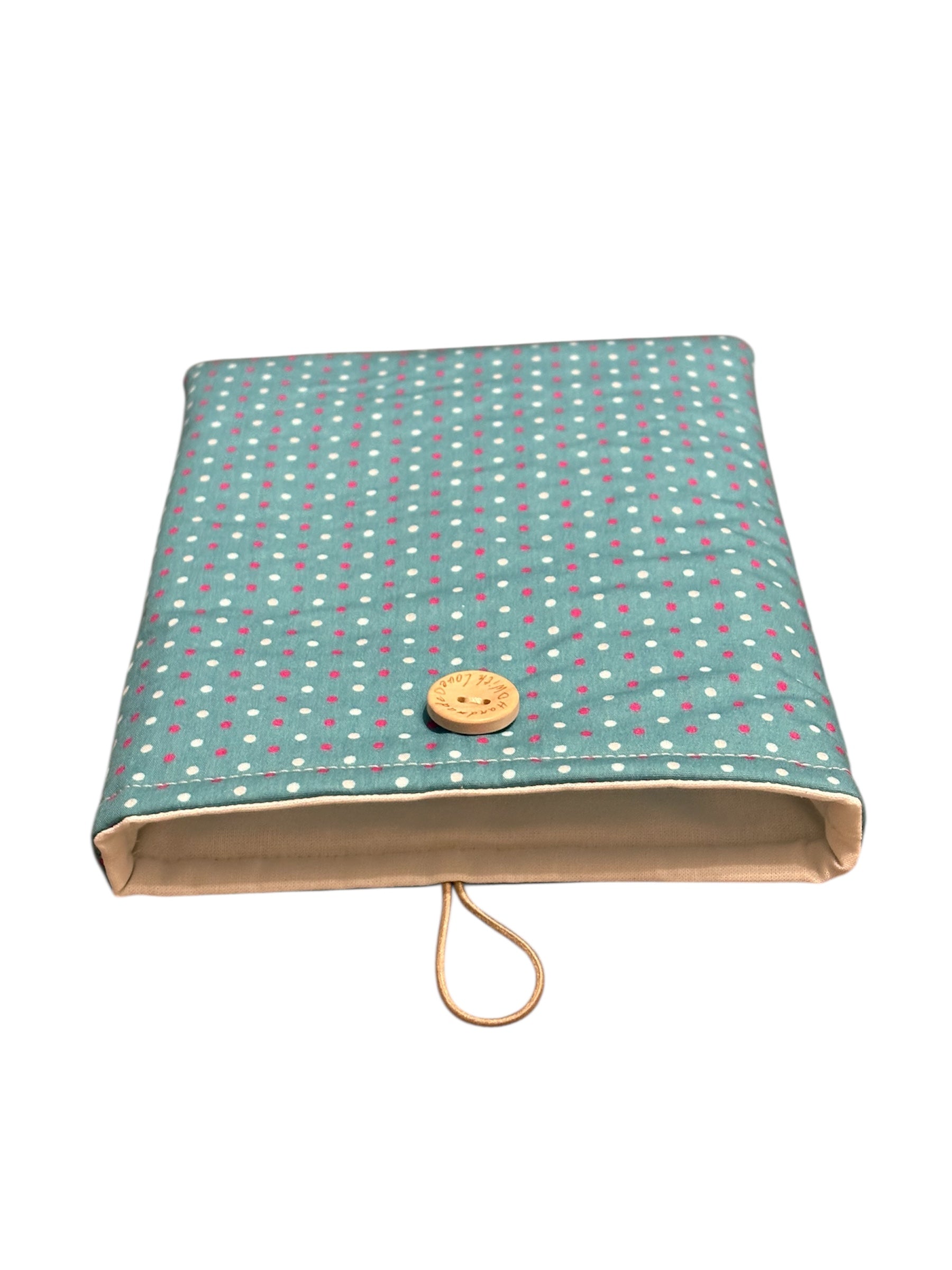 The handmade padded Book Cover is lined with neutral fabric, padded with fusible wadding and has elastic and button fastening.