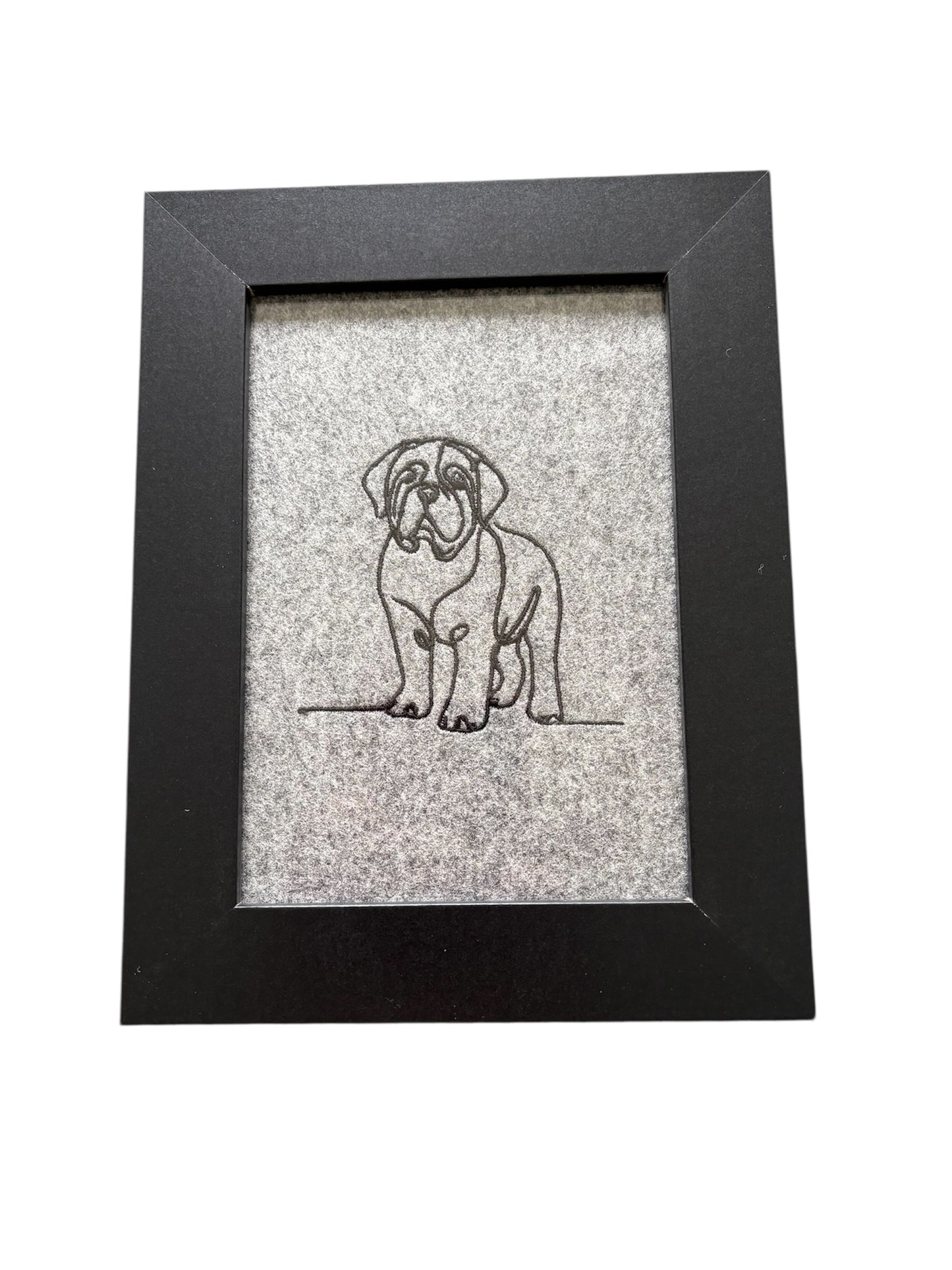 This is a machine embroidered sketch style Mastiff dog on light grey boiled wool.  The embroidered dog pattern has been mounted in a black wooden frame which is 8 inches by 6 inches, with a display area of 4 inches by 6 inches.