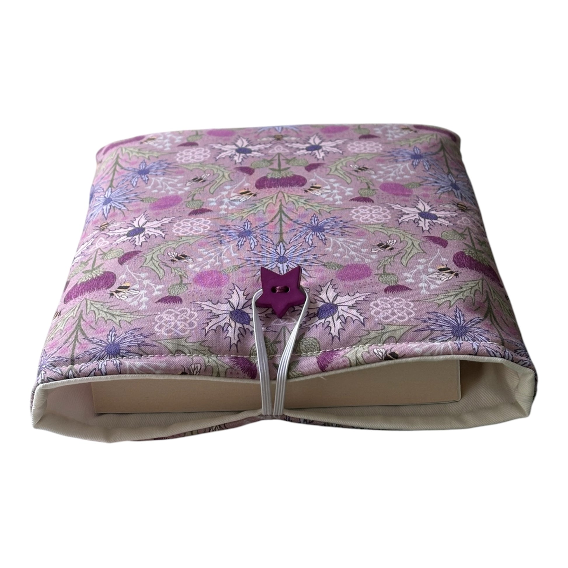 The handmade Book Pouch is padded with polyester wadding, lined with neutral fabric and has button and elastic fastening.  Please note the book in the photo is for illustrative purposes only and is not included.