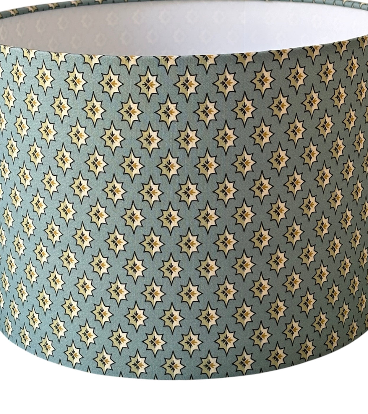 A close up of the stylish fabric and the star like pattern on a blue background.  Although the pattern is the direction indicated in the photo and, therefore, made for a lamp base, it is personal choice if used for a ceiling fitting.