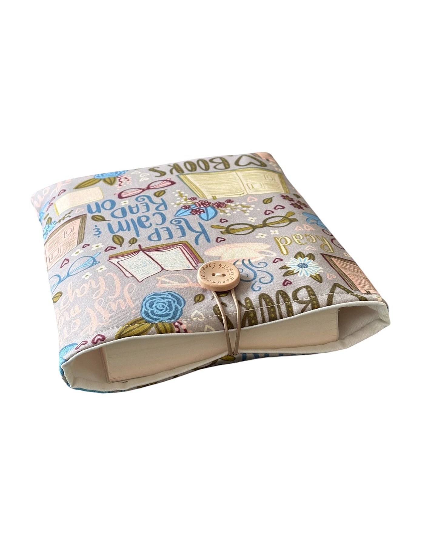 Keep Calm & Read On with this lightly padded book themed fabric Book Pouch.  The Book Cover is complemented with neutral fabric lining the inside but please note the book is not included and is for illustrative purposes only.
