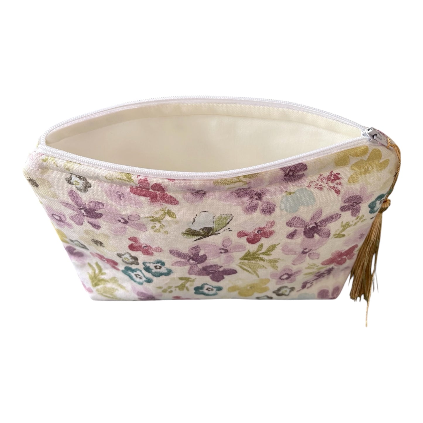 The handmade make up purse is made with pretty pastel floral fabric, lined with neutral cream fabric and fastens with a white zip.