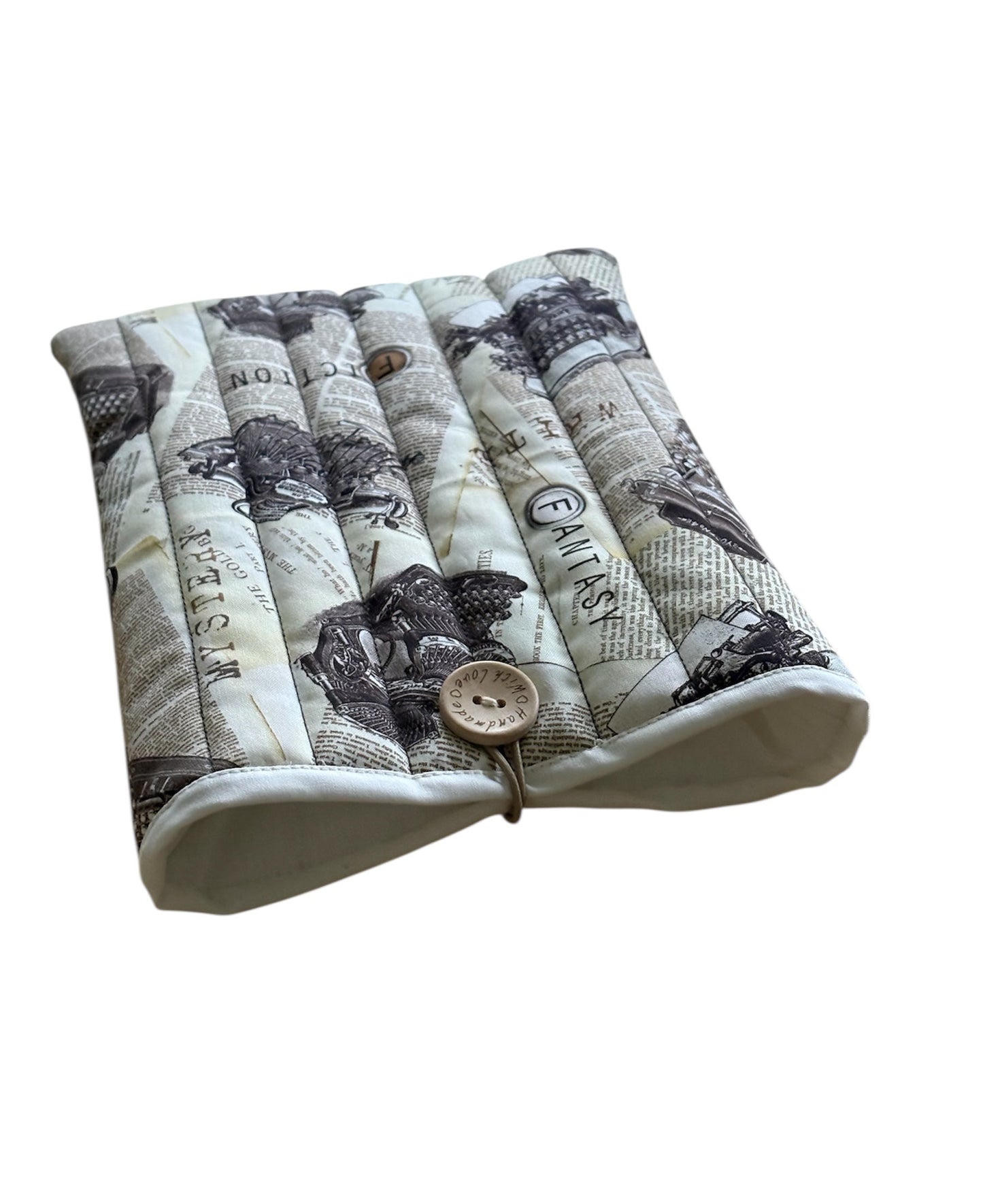 The handmade Book Cover is lined with neutral fabric, padded with fusible wadding and has elastic and button closure.
