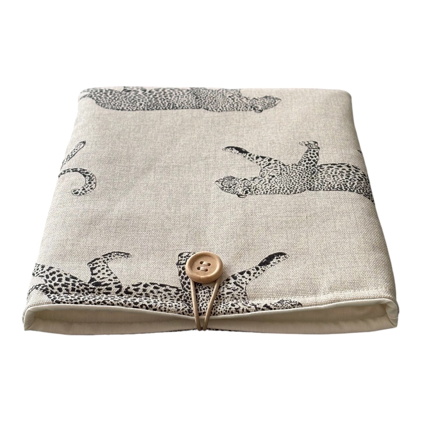 The handmade Book Pouch is padded with wadding, lined with neutral fabric and has wooden button and elastic fastening.