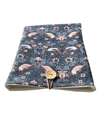The handmade Book Pouch has elastic and button fastening as shown in the photo.  The neutral lining can also be seen in the photo.
