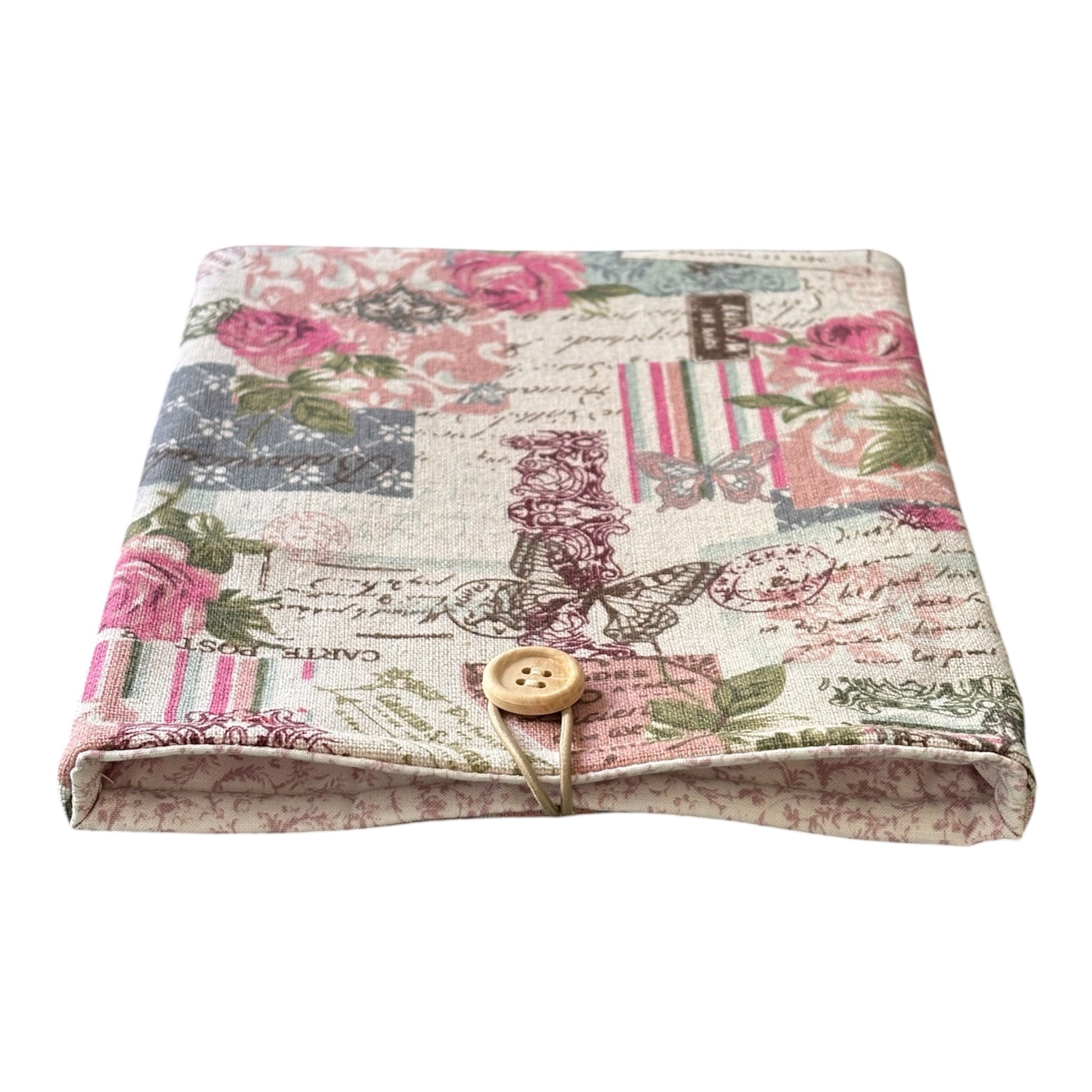 The handmade Book Cover is padded with fusible fleece, lined with complementing delicate pink floral style fabric and has elastic and button fastening.